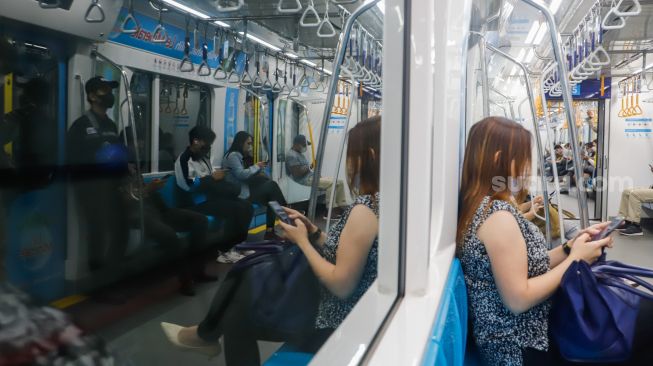 Penumpang menaiki rangkaian MRT Jakarta di Stasiun Bundaran HI, Jakarta, Rabu (22/2/2023). [Suara.com/Alfian Winanto]