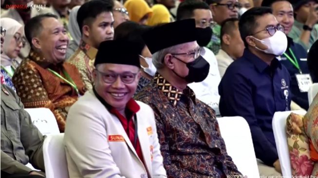 Ketua Umum PP Pemuda Muhammadiyah, Sunanto tertawa mendengar guyonan Presiden Joko Widodo atau Jokowi saat berpidato dalam acara Pembukaan Muktamar XVIII PP Pemuda Muhammadiyah Tahun 2023, Balikpapan, Rabu (22/2/2023).  (YouTube Sekretariat Presiden)