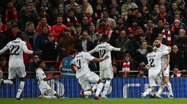 Para pemain Real Madrid merayakan gol Karim Benzema (kanan) setelah mencetak gol keempat timnya pada pertandingan sepak bola leg pertama babak 16 besar Liga Champions UEFA antara Liverpool dan Real Madrid di Anfield di Liverpool, barat laut Inggris pada 21 Februari 2023. Paul ELLIS / AFP