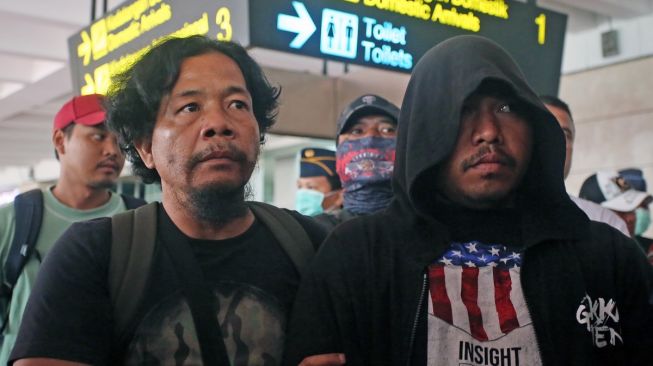 Anggota polisi Resmob Polda Metro Jaya membawa seorang debt collector pelaku pemaki petugas kepolisian Lesly Watimena (kanan) setibanya dari Ambon di Terminal 2 Bandara Soekarno Hatta, Tangerang, Banten, Kamis (23/02/2023). Polisi menangkap tiga orang pelaku, satu di antaranya ditangkap di Pulau Saparua, Ambon. [ANTARA FOTO/Muhammad Iqbal]