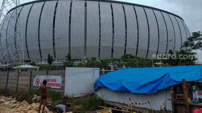 Aktivitas warga di tenda darurat yang didirikan di pintu masuk Jakarta International Stadium (JIS), Jakarta Utara, Jumat (24/2/2023). [Suara.com/Alfian Winanto]