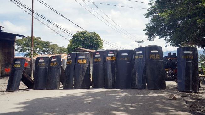 Polisi meletakkan tameng-tameng mereka usai bertugas saat kerusuhan massa di Wamena, Papua, Jumat (24/2/2023). [ANTARA FOTO/Iwan Adisaputra].