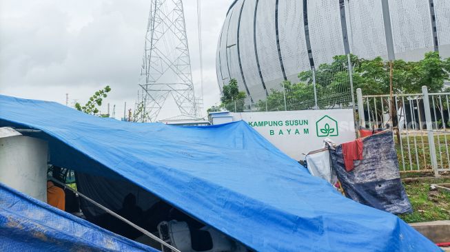 Aktivitas warga di tenda darurat yang didirikan di pintu masuk Jakarta International Stadium (JIS), Jakarta Utara, Jumat (24/2/2023). [Suara.com/Alfian Winanto]