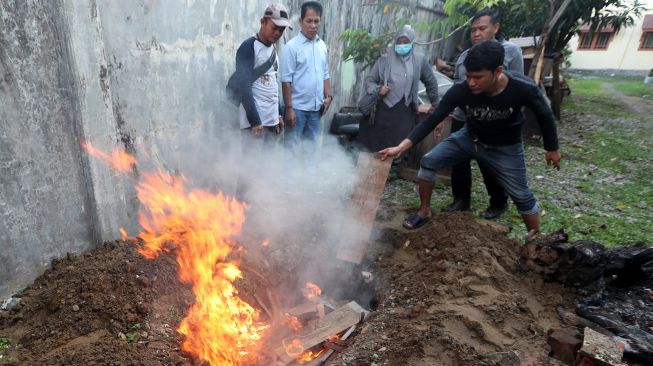 Petugas Balai Konservasi Sumber Daya Alam (BKSDA) Aceh membakar kantung berisi bangkai Harimau Sumatera (Panthera tigris sumatrae) sebelum dikuburkan di Banda Aceh, Aceh, Jumat (24/2/2024). [ANTARA FOTO / Irwansyah Putra].