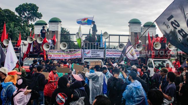 Massa dari sejumlah elemen Buruh, Mahasiswa dan Pekerja saat menggelar aksi demo menolak Perppu Cipta Kerja di depan gedung DPR/MPR RI, Senayan, Jakarta Pusat, Selasa (28/2/2023). [Suara.com/Alfian Winanto]