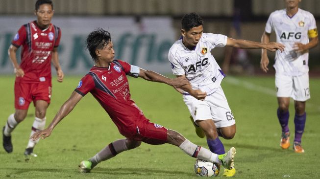 Pesepak bola Arema FC Johan Ahmad Farizi (kiri) berebut bola dengan pesepak bola Persik Kediri Rangga Widiansyah (kanan) pada pertandingan Liga 1 di Stadion PTIK, Jakarta, Selasa (28/2/2023). Persik Kediri menang 3-2 atas Arema FC. ANTARA FOTO/Wahyu Putro A/rwa. 