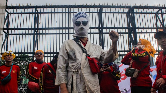 Massa dari sejumlah elemen Buruh, Mahasiswa dan Pekerja saat menggelar aksi demo menolak Perppu Cipta Kerja di depan gedung DPR/MPR RI, Senayan, Jakarta Pusat, Selasa (28/2/2023). [Suara.com/Alfian Winanto]