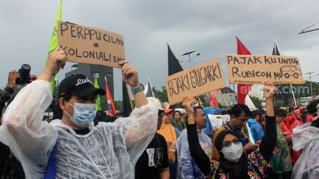 Massa dari sejumlah elemen Buruh, Mahasiswa dan Pekerja saat menggelar aksi demo menolak Perppu Cipta Kerja di depan gedung DPR/MPR RI, Senayan, Jakarta Pusat, Selasa (28/2/2023). [Suara.com/Alfian Winanto]