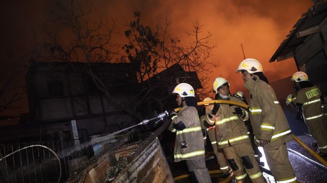A number of officers tried to extinguish the fire that burned the houses of residents affected by the fire at the Pertamina Plumpang Depot, Jalan Koramil area, Rawa Badak Selatan, Koja, North Jakarta, Friday (3/3/2023).  (BETWEEN PHOTOS/M Risyal Hidayat).