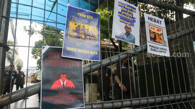Massa melakukan aksi simbolik 'Koin Peduli untuk Ditjen Pajak' di depan Kantor Direktorat Jendral Pajak, Senayan, Jakarta Selatan, Kamis (3/3/2023). [Suara.com/Alfian Winanto]