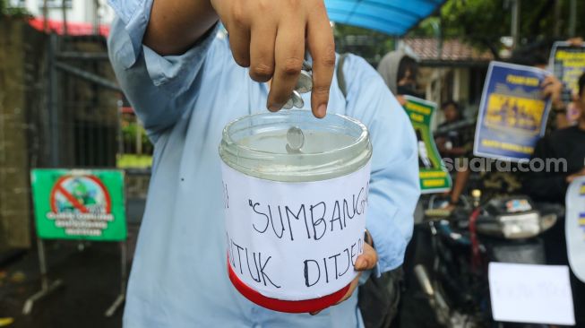 Massa melakukan aksi simbolik 'Koin Peduli untuk Ditjen Pajak' di depan Kantor Direktorat Jendral Pajak, Senayan, Jakarta Selatan, Kamis (3/3/2023). [Suara.com/Alfian Winanto]