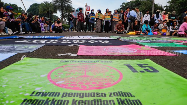 Sejumlah aktivis saat menggelar aksi unjuk rasa terkait krisis iklim di Kawasan Patung Kuda, Jakarta Pusat, Jumat (3/3/2023). [Suara.com/Alfian Winanto]