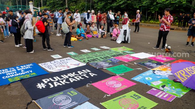 Sejumlah aktivis saat menggelar aksi unjuk rasa terkait krisis iklim di Kawasan Patung Kuda, Jakarta Pusat, Jumat (3/3/2023). [Suara.com/Alfian Winanto]