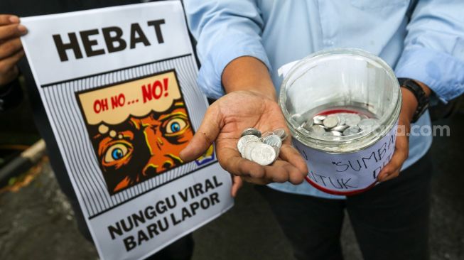 Massa melakukan aksi simbolik 'Koin Peduli untuk Ditjen Pajak' di depan Kantor Direktorat Jendral Pajak, Senayan, Jakarta Selatan, Kamis (3/3/2023). [Suara.com/Alfian Winanto]