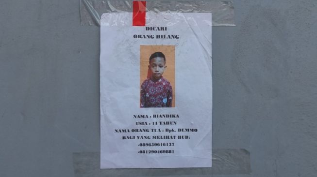 Poster pencarian terhadap Riandika (11) seorang bocah lelaki yang masih dinyatakan hilang pasca kebakaran Depo Pertamina Plumpang. [Suara.com/Faqih Fachturrahman)