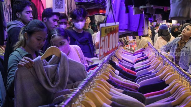 Calon pembeli memilih baju bekas impor di Pasar Senen, Jakarta Pusat, Selasa (7/3/2023). [Indonesia/Alfian Winanto]