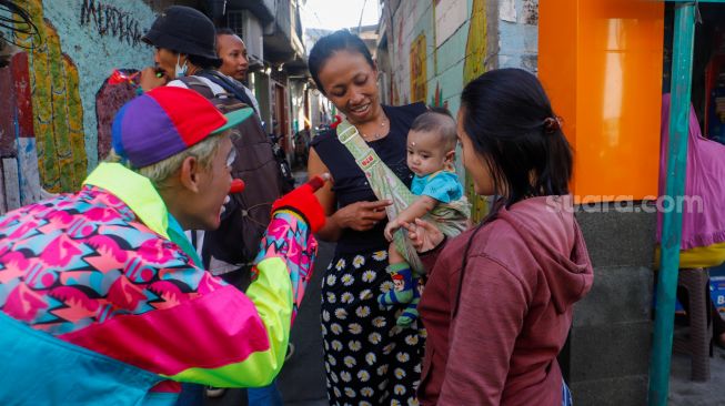 Sejumlah Badut yang tergabung dalam komunitas Aku Badut Indonesia (ABI) menghibur anak-anak di sekitar lokasi kebakaran Depo Pertamina Plumpang di Koja, Jakarta Utara, Rabu (8/3/2023). [Suara.com/Alfian Winanto]