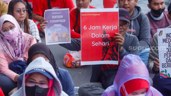 Para peserta melakukan aksi di sekitar Patung Kuda Arjuna Wiwaha, Jakarta Pusat, Rabu (8/3/2023). [Suara.com/Alfian Winanto]