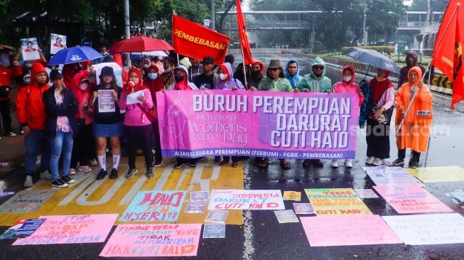 Para peserta melakukan aksi di sekitar Patung Kuda Arjuna Wiwaha, Jakarta Pusat, Rabu (8/3/2023). [Suara.com/Alfian Winanto]