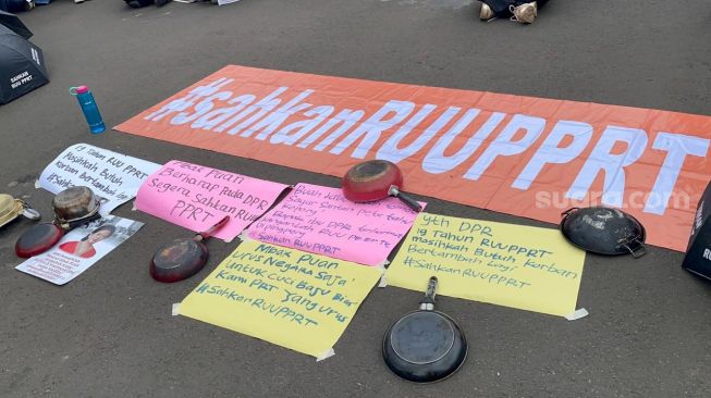 Sejumlah perempuan yang tergabung dari berbagai elemen melakukan aksi unjuk rasa di depan Gedung DPR RI, Senayan, Jakarta, Rabu (8/3/2023). (Suara.com/Bagaskara)