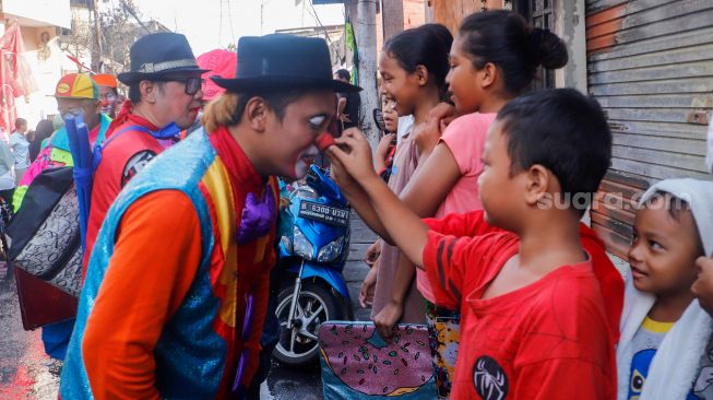 Sejumlah Badut yang tergabung dalam komunitas Aku Badut Indonesia (ABI) menghibur anak-anak di sekitar lokasi kebakaran Depo Pertamina Plumpang di Koja, Jakarta Utara, Rabu (8/3/2023). [Suara.com/Alfian Winanto]