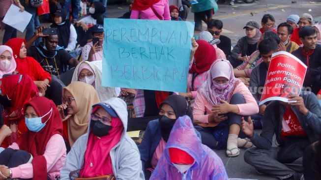 Para peserta melakukan aksi di sekitar Patung Kuda Arjuna Wiwaha, Jakarta Pusat, Rabu (8/3/2023). [Suara.com/Alfian Winanto]