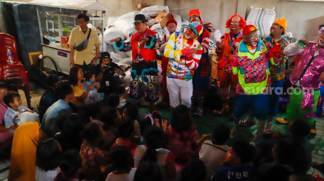 Sejumlah Badut yang tergabung dalam komunitas Aku Badut Indonesia (ABI) menghibur anak-anak di pengungsian korban kebakaran Depo Pertamina Plumpang di Koja, Jakarta Utara, Rabu (8/3/2023). [Suara.com/Alfian Winanto]