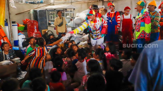 Sejumlah Badut yang tergabung dalam komunitas Aku Badut Indonesia (ABI) menghibur anak-anak di pengungsian korban kebakaran Depo Pertamina Plumpang di Koja, Jakarta Utara, Rabu (8/3/2023). [Suara.com/Alfian Winanto]