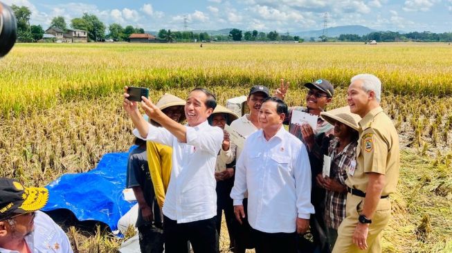 Gubernur Jawa Tengah Ganjar Pranowo mengajak selfie Presiden Joko Widodo atau Jokowi dan Menteri Pertahanan (Menhan) Prabowo Subianto yang tengah meninjau panen raya di Kebumen, Jawa Tengah, Kamis (9/3/2023).  (Laily Rachev – Biro Pers Sekretariat Presiden)