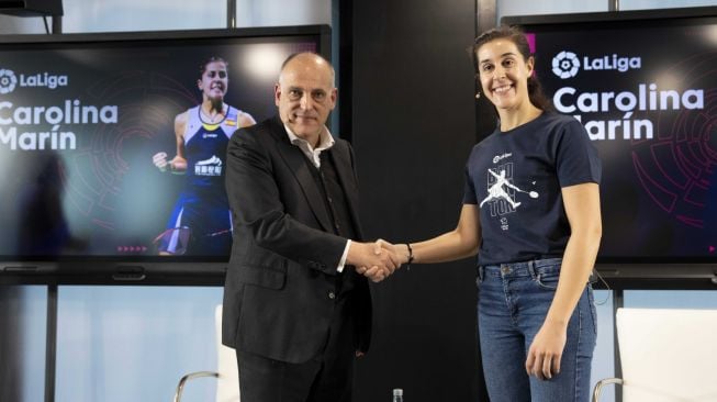 Pebulu tangkis putri Spanyol, Carolina Marin (kanan) bersalaman dengan Presiden LaLiga, Javier Tebas dalam konferensi pers pengumuman perpanjangan kerjasama atau kolaborasi antara dirinya dan LaLiga di Madrid, Spanyol pada Rabu (8/3/2023). [LaLiga]