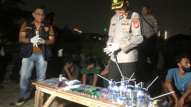 Polisi menunjukan sejumlah alat yang diduga digunakan untuk menghisap sabu hasil penggerebekan di Kampung Boncos, Jakarta Barat. [Suara.com/Faqih]