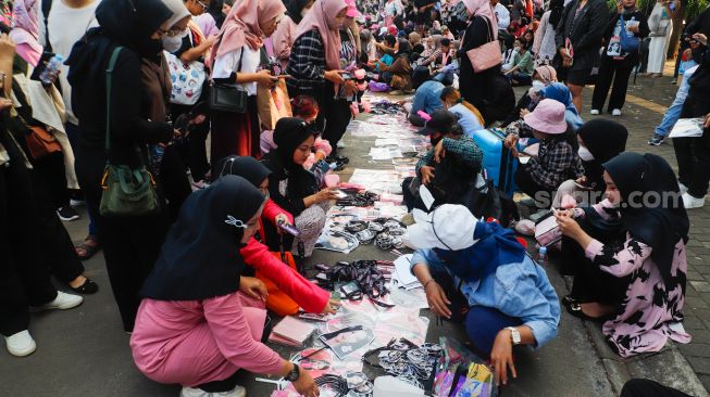 Pedagang menjajakan dagangannya saat konser BLACKPINK di area Gelora Bung Karno (GBK), Jakarta Pusat,  Sabtu (11/3/2023). [Suara.com/Alfian Winanto]