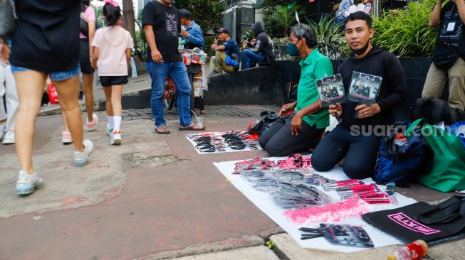 Pedagang menjajakan dagangannya saat konser BLACKPINK di area Gelora Bung Karno (GBK), Jakarta Pusat,  Sabtu (11/3/2023). [Suara.com/Alfian Winanto]