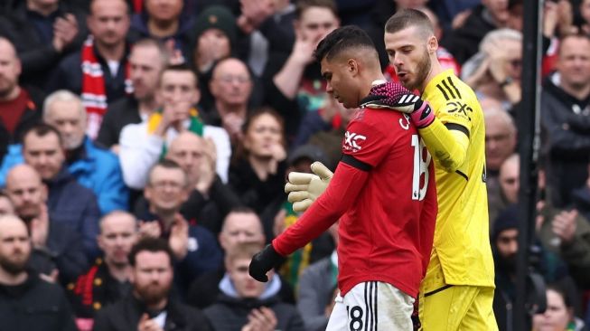 Gelandang Manchester United, Casemiro (kiri) berjalan ke luar lapangan usai kena kartu merah pada laga Liga Inggris kontra Southampton di Old Trafford, Minggu (12/3/2023) malam WIB. [DARREN STAPLES / AFP]