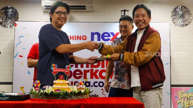 Direktur Utama PT Arkadia Digital Media, Suwarjono (kanan) memberikan nasi tumpeng secara simbolik kepada karyawan Suara.com saat perayaan Ulang Tahun ke-9 Suara.com di Kuningan, Jakarta, Senin (13/3/2023). [Suara.com/Alfian Winanto]