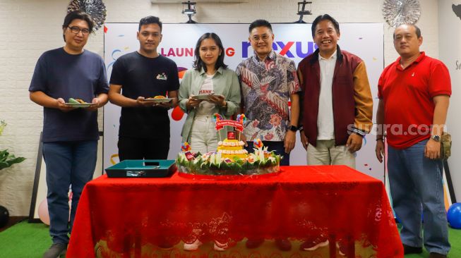 Direktur Utama PT Arkadia Digital Media, Suwarjono (kedua kanan), Komisaris Iwa Sukresno Karunia (ketiga kanan) dan Direktur Erfan Suryono (kanan) dan karyawan Suara.com foto bersama usai pemotongan nasi tumpeng saat perayaan Ulang Tahun ke-9 Suara.com di Kuningan, Jakarta, Senin (13/3/2023). [Suara.com/Alfian Winanto]