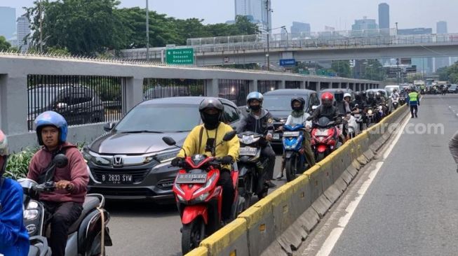 Pengendar dialihkan ke jalur TransJakarta imbas adanya demo di Gedung DPR RI, Senin (13/3/2023). (Suara.com/Rakha)