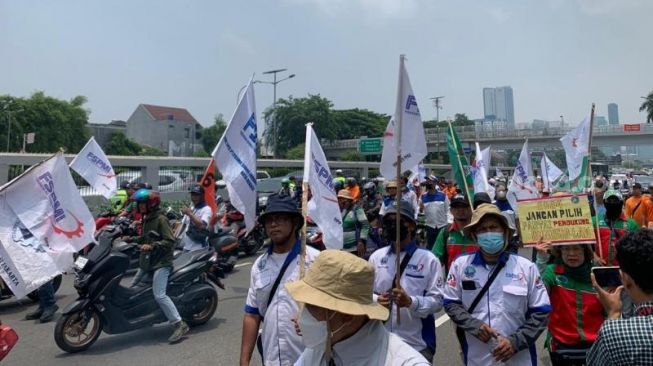 Sejumlah buruh tengah long march ke Gedung DPR RI, Senin (13/3/2023). (Suara.com/Rakha)