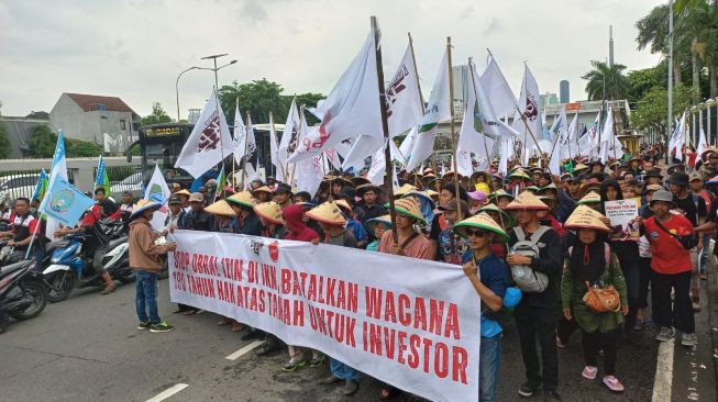 Ribuan massa aksi yang tergabung dalam Gerakan Buruh Bersama Rakyat (Gebrak) menggeruduk di depan Gedung DPR RI, Senayan, Jakarta, pada Selasa (14/3/2023). [Suara.com/Faqih]