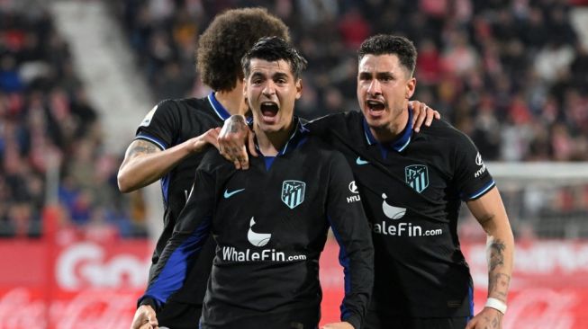 Penyerang Atletico Madrid asal Spanyol Alvaro Morata (tengah) melakukan selebrasi dengan Axel Witsel (kiri) dan Jose Gimenez usai mencetak gol kemenangan timnya selama pertandingan pekan ke-25 Liga Spanyol 2022-2023 antara Girona vs Atletico Madrid di stadion Montilivi di Girona pada 13 Maret 2023.GEN LLUIS / AFP.