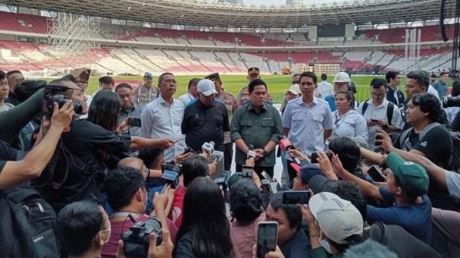 Ketua umum PSSI Erick Thohir (baju hijau) menjawab pertanyaan para pewarta setelah meninjau lapangan Stadion Utama Gelora Bung Karno, Jakarta, Senin (13/3/2023). (ANTARA/RAUF ADIPATI)