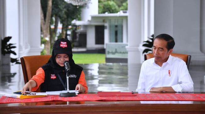 Petugas Panitia Pemuthakiran Data Pemilih (Pantarlih) Kelurahan Gambir Feby Azza Nurhakim melakukan pencocokan dan penelitian (coklit) data pemilih kepada Presiden Joko Widodo di Istana Merdeka, Jakarta, Selasa (14/3/2023). [Foto: Rusman - Biro Pers Sekretariat Presiden]