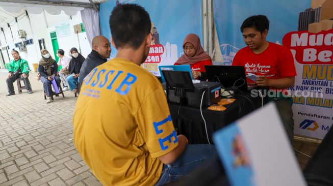 Warga melakukan verivikasi data untuk pendaftaran mudik gratis di Gelanggang Olahraga (GOR) Bulungan, Jakarta Selatan, Rabu (15/3/2023). [Suara.com/Alfian Winanto]