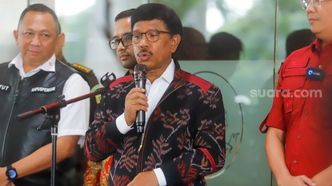 Menteri Komunikasi dan Informatika (Menkominfo) Johnny G Plate (tengah) memberikan keterangan usai menjalani pemeriksaan sebagai saksi di Kejaksaan Agung, Jakarta Selatan, Rabu (15/3/2023). [Suara.com/Alfian Winanto]