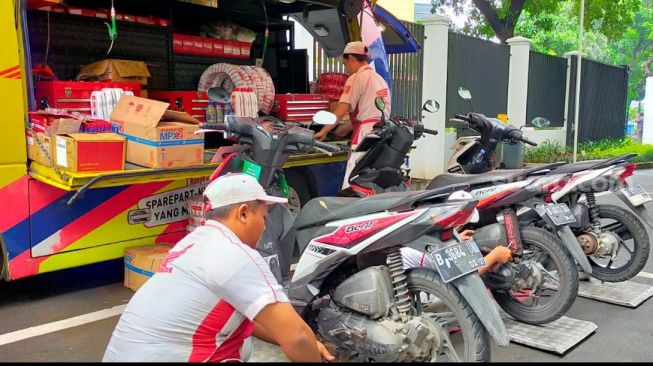 Para teknisi Semok (Service Motor Keliling) Honda dari Wahana tengah melakukan pemeriksaan kesehatan motor serta mengganti sparkplug (busi) dan oli tunggangan para jurnalis Suara.com [Suara.com/CNR ukirsari].