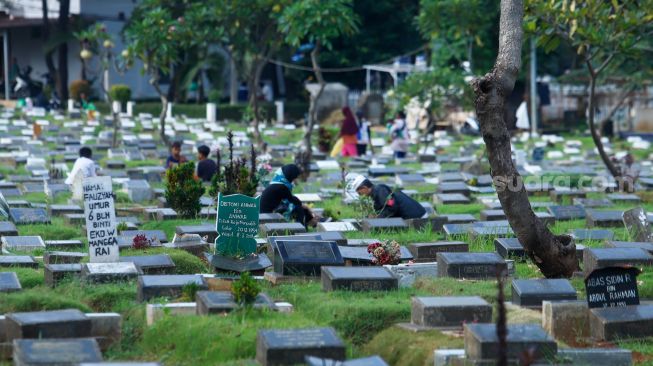 Warga melakukan ziarah makam di TPU Menteng Pulo, Jakarta Pusat, Jumat (17/3/2023). [Suara.com/Alfian Winanto]