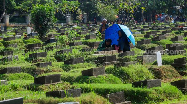 Warga melakukan ziarah makam di TPU Menteng Pulo, Jakarta Pusat, Jumat (17/3/2023). [Suara.com/Alfian Winanto]