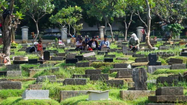 Warga melakukan ziarah makam di TPU Menteng Pulo, Jakarta Pusat, Jumat (17/3/2023). [Suara.com/Alfian Winanto]