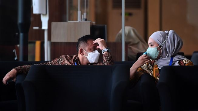 Kepala Badan Pertanahan Nasional (BPN) Jakarta Timur, Sudarman Harjasaputra (kiri) bersama istri Vidya Piscarista bersiap untuk dimintai klarifikasi terkait harta kekayaan di Gedung Merah Putih KPK, Jakarta, Selasa (21/3/2023). [ANTARA FOTO/Sigid Kurniawan.