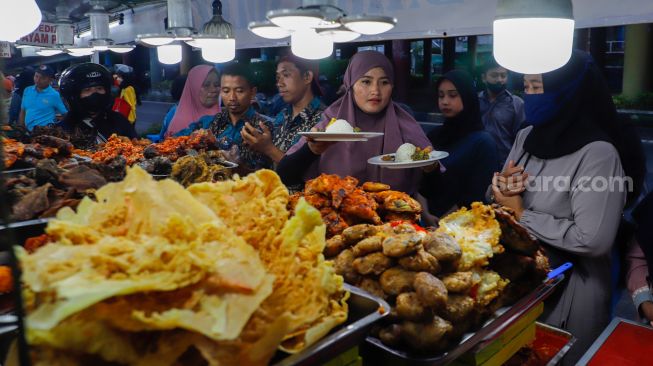 Pengunjung memilih menu berbuka puasa di Sentra kuliner Nasi Kapau di Jalan Kramat Raya, Senen, Jakarta Pusat, Jumat (24/3/2023). [Suara.com/Alfian Winanto]